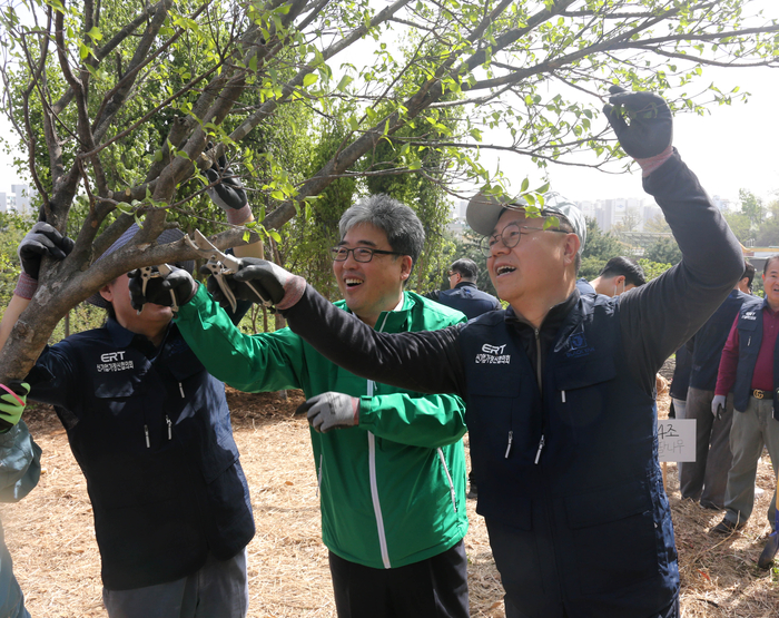 박일준 대한상의 상근부회장(오른쪽)과 임상섭 산림청 차장(가운데)이 산딸나무에 가지치기를 하고 있다.