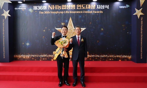 18일 농축협 연도대상 시상식에서 윤해진 NH농협생명 대표(오른쪽)와 개인 부문 대상 수상자 하남농협 엄기화 팀장(왼쪽)이 연도대상 기념 촬영을 진행하고 있다(사진=NH농협생명)