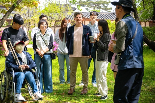 라이언 브라운 쿠팡풀필먼트서비스 EHS부문 대표이사(가운데)가 지난 18일 서울 종로구 창덕궁에서 직원들과 함께 숲 해설사의 이야기를 듣고 있다. [자료:쿠팡]