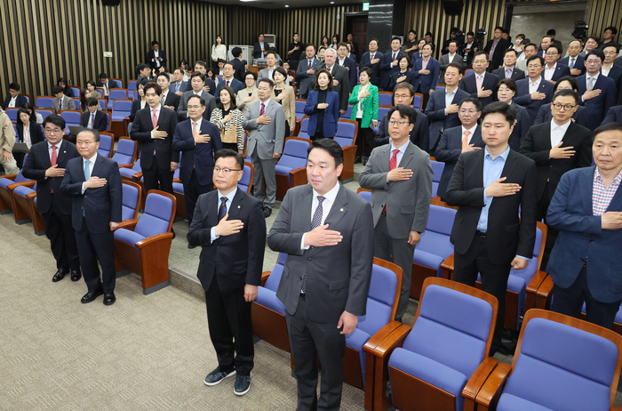 국민의힘 윤재옥 원내대표 겸 당 대표 권한대행을 비롯한 당 지도부와 당선인들이 29일 국회에서 열린 제22대 국회의원 당선자 총회에서 국기에 경례하고 있다.