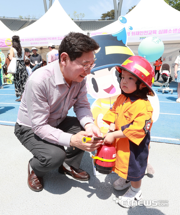 이상일 경기 용인시장이 지난 4일 용인미르스타디움에서 열린 '용인특례시 어린이날 대축제'에 참석해 한전체험존에서 소방관이 된 아이에게 소화기 사용법을 알려줬다.