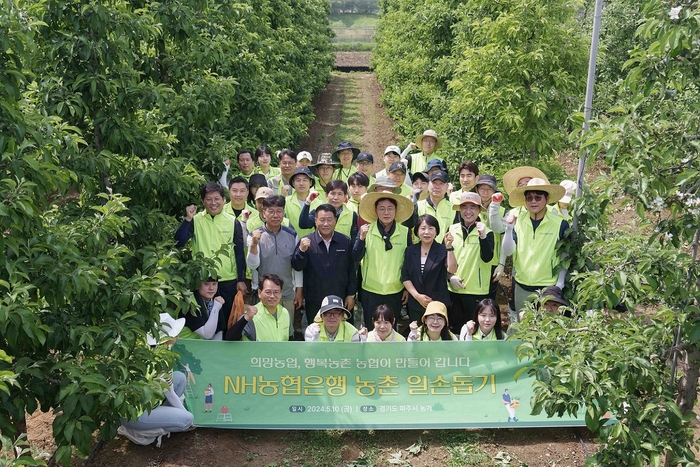 10일 농협은행 임직원들이 사과 재배농가를 찾아 일손돕기에 나섰다. 이석용 은행장(둘째줄 가운데)과 임직원 봉사단원들이 기념촬영을 하고 있다. 사진제공=NH농협은행