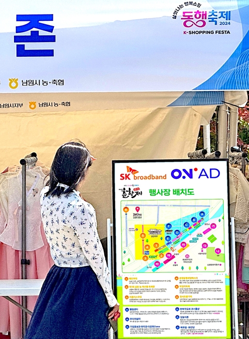 '춘향제' 관광객이 'B tv 온애드'로 축제 정보를 보고 있다.