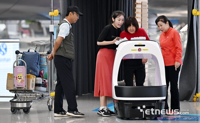 탄소중립을 주제로 한 과학·예술 융합형 전시 2024 인천공항 탄소C그널 기획전이 오는 8월 15일까지 인천국제공항 제1교통센터에서 열린다. 여행객이 넷제로 에어포트 인천공항관에 마련된 에어포터(카트로봇)을 살펴보고 있다.   이동근기자 foto@etnews.com