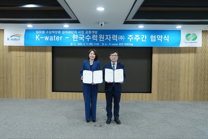 한수원이 한국수자원공사와 '임하댐 수상태양광사업 주주간 협약'을 체결했다 (오른쪽) 윤상조 한수원 그린사업본부장과 (왼쪽) 오은정 한국수자원공사 환경에너지본부장이 기념촬영을 하고 있다. (사진=한수원)