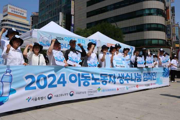 '2024년 이동노동자 생수나눔 공동사업단'이 지난 12일 이동노동자에게 생수 10만6000병을 제공했다. 참석자들이 기념사진을 촬영하고 있다. 〈자료 우아한청년들〉