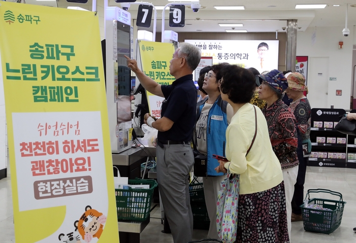 롯데마트 송파점에서 '느린 키오스크 캠페인'이 진행된 가운데 노인들이 키오스크 사용 교육을 받고 있다. 사진=송파구청