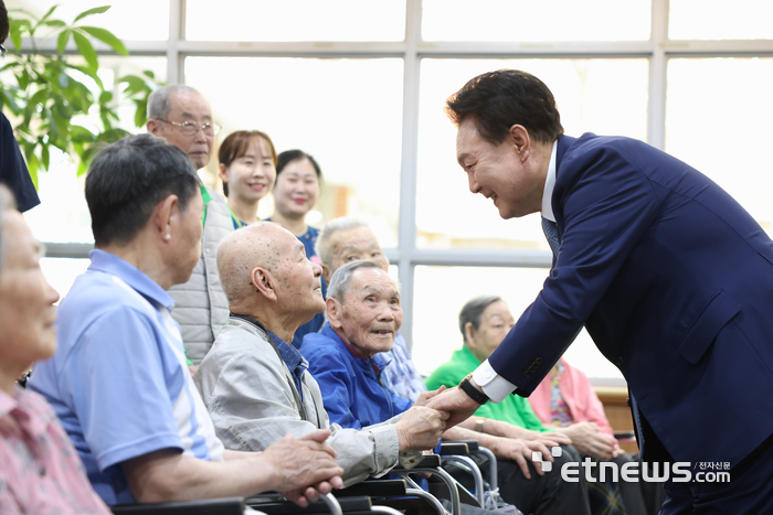 윤석열 대통령이 21일 경기도 수원시 장안구 보훈요양원을 방문해 '나라사랑 액자 만들기' 체험활동 뒤 프로그램에 참여한 참전용사 및 전상·전몰군경 유족 어르신들과 인사하고 있다. 대통령실 제공