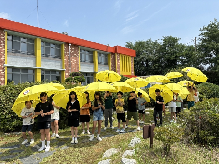 LG헬로비전은 지난 3일(수) 전북 부안남초등학교에서 '어린이가 만드는 기후동행학교' 프로그램을 진행했다. 사진은 학생들이 플라스틱으로 만들어진 안전우산을 들고 있는 모습.