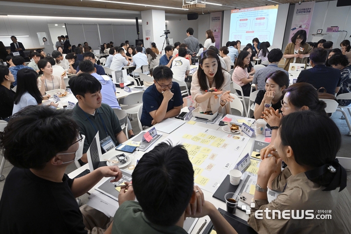 'AI 디지털교과서 디자인 워크숍'에 참석한 교사들이 모둠별로 AI 디지털교과서 개발을 위한 아이디어를 모으고 있다. 김민수기자 mskim@etnews.com