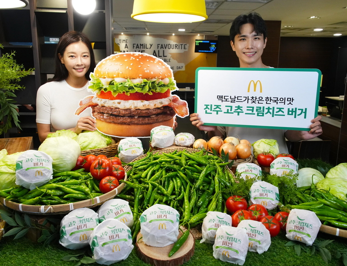 모델이 맥도날드 진주 고추 크림치즈 버거를 소개하고 있다.