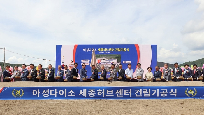 아성다이소 박정부 회장(왼쪽에서 열두번째)과세종시 이승원 경제부시장(왼쪽에서 열세번째)을 비롯한내빈들이 25일 세종스마트그린산업단지에서 열린 세종허브센터 건립 기공식에서 시삽세레머니를 하고 있다.