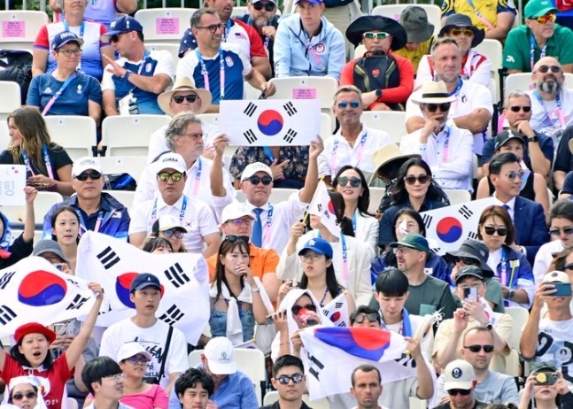 정의선 현대차그룹 회장이 28일(현지시간) 파리 올림픽 양궁 여자 단체전 경기를 찾아 태극기를 펼치며 응원하고 있다. 정 회장 오른쪽으로 부인 정지선씨, 이서현 삼성물산 전략기획담당 사장, 김재열 IOC 위원(삼성글로벌리서치 사장)