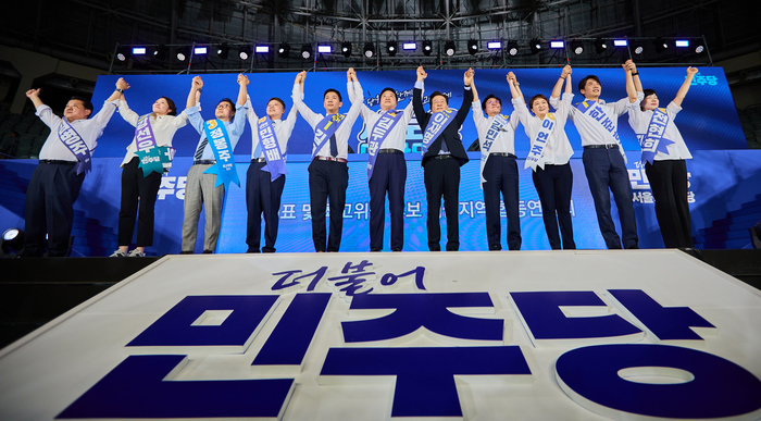 17일 오후 서울 중구 장충체육관에서 열린 더불어민주당 서울시당 제1차 정기전국당원대회 및 당대표·최고위원 후보자 합동연설회에서 당대표 및 최고위원 후보들이 손을 들어보이고 있다. 이재명 캠프 제공