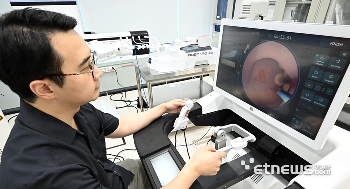 국산 인공지능(AI) 수술로봇 상용화에 성공한 가운데 후속 연구개발(R&D)이 활발하게 이어지고 있다. 로엔서지컬에서 엔지니어들이 AI기반 완전 로봇식 신장결석 수술로봇 '자메닉스'를 점검하고 있다. 자메닉스는 결석이 요관을 통과할 수 있는 사이즈인지를 안내하는 AI 기능이 탑재돼 있어 큰 결석은 레이저로 쪼개 요관 손상 없이 제거하며, 내시경이 다녀간 경로를 학습해 경로 재생 기능으로 의료진의 피로도를 낮춘다.   이동근기자 foto@etnews.com