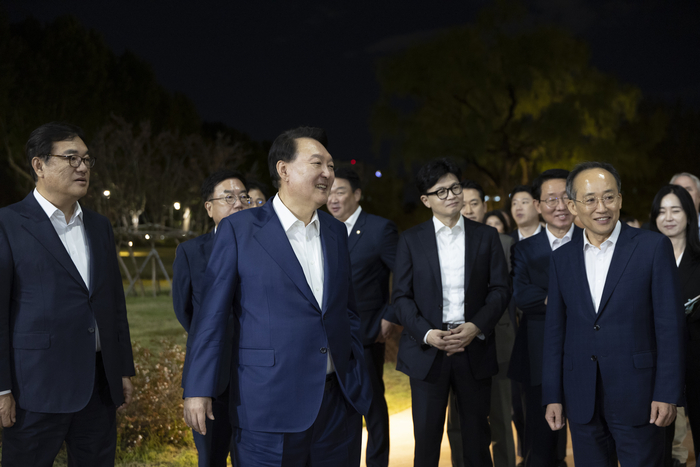 윤석열 대통령이 24일 용산 대통령실 앞 분수정원에서 열린 국민의힘 지도부 초청 만찬 뒤 한동훈 대표, 추경호 원내대표 등 국민의힘 지도부, 대통령실 참모진과 함께 산책을 하고 있다. 대통령실 제공