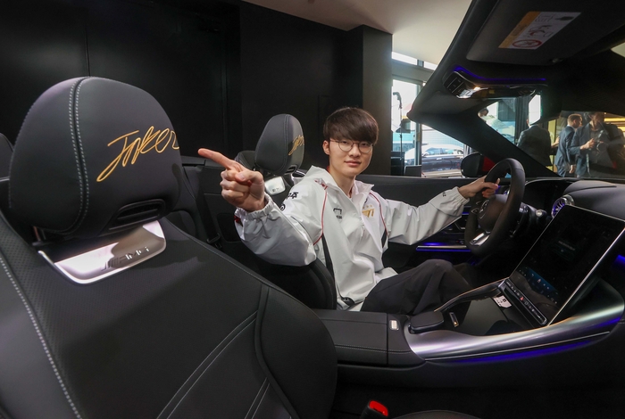 이상혁 선수가 메르세데스-AMG SL 머리 받침대에 새겨진 페이커를 가리키고 있다.