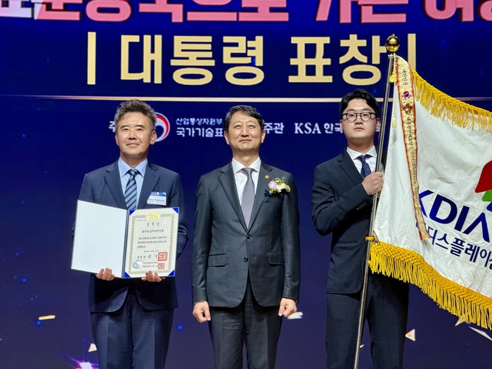 이동욱 한국디스플레이산업협회 부회장(왼쪽)이 15일 서울 중구 대한상공회의소에서 열린 '세계 표준의 날' 기념식에서 유공단체 부문 대통령 표창을 받고 안덕근 산업통상자원부 장관(가운데)과 기념촬영하고 있다. 〈사진 한국디스플레이산업협회 제공〉