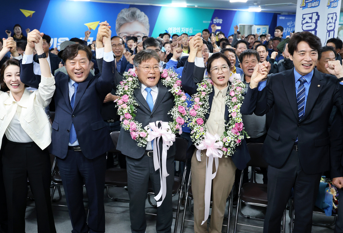 10ㆍ16 재ㆍ보궐선거가 실시된 16일 오후 전남 영광군수 재선거에서 당선이 확실시된 더불어민주당 장세일 후보가 배우자 정수미 씨와 화환을 목에 걸고 지지자들에게 인사하고 있다. 연합뉴스