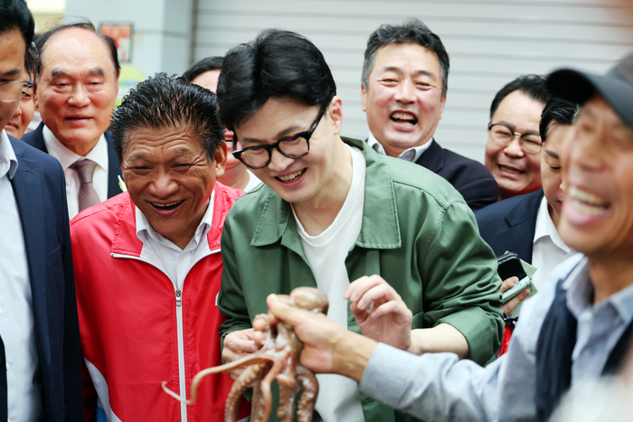 국민의힘 한동훈 대표가 18일 오전 전남 곡성기차마을전통시장에서 상인이 건넨 낙지를 보고 웃고 있다.