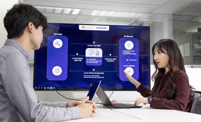 SK텔레콤과 삼성전자 연구원이 AI 기반 5G 기지국 품질 최적화 기술 실증에 대해 논의하는 모습