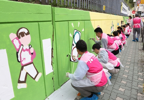 25일 흥국생명 임직원들이 서울 서초구 서일초등학교에서 스쿨존 벽화 그리기 봉사활동을 하고 있다.(사진=흥국생명)