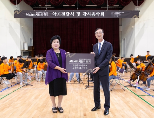 31일 대전 대덕구 대전동도초등학교에서 열린 '제17회 맥심 사랑의 향기' 행사에서 동서식품 최상인 홍보상무(오른쪽)와 강창숙 대전동도초등학교 교장이 기념촬영을 하고 있다. [자료:동서식품]