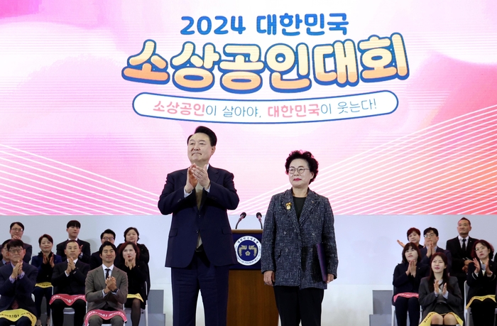 윤석열 대통령이 31일 경기도 고양시 킨텍스에서 열린 '2024 대한민국 소상공인대회 개막식'에서 라복임플로체 라복임 대표에게 대통령 표창을 수여한 뒤 박수치고 있다. 연합뉴스