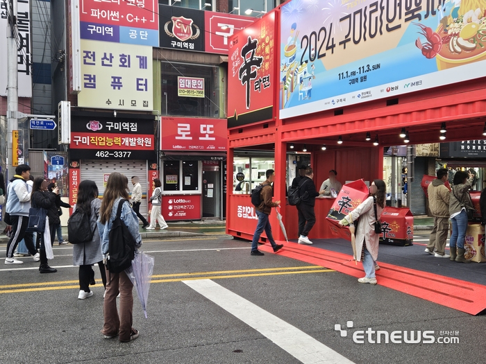 구미라면축제에 설치된 신라면 출입구 앞에서 사람들이 기념사진을 촬영하고 있다. 〈사진=강성전기자〉