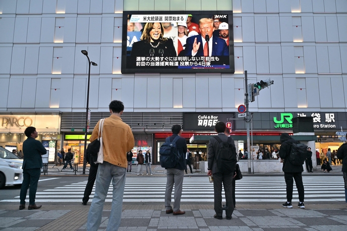 일본 도쿄에서 시민들이 지나가며 스크린을 통해 미국 대선을 지켜보고 있다. 〈사진 AFP, 연합뉴스〉