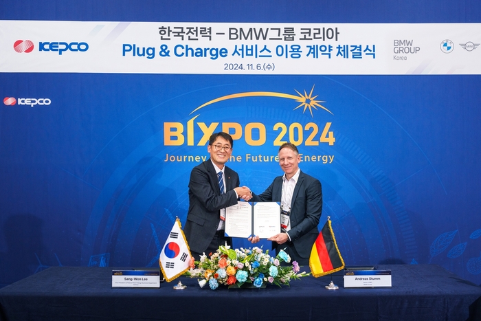 안드레아스 스툼 BMW그룹 R&D센터 코리아 총괄(오른쪽)과 이상원 한국전력 에너지신사업처장이 PnC 충전 서비스 이용 계약 체결식에서 기념 촬영하고 있다.