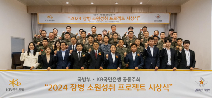 지난 7일 서울시 용산구에 위치한 국방컨벤션에서 열렸던 '2024 장병소원성취 프로젝트'시상식에서 윤봉희 국방부 정책기획관(맨앞줄 좌측 5번째)과 서영익 KB국민은행 기관영업그룹대표(맨앞줄 좌측 6번째)가 수상자들과 함께 기념촬영을 하고 있다.