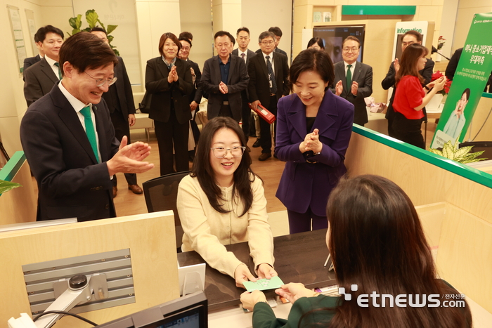 오영주 중소벤처기업부 장관(오른쪽)이 13일 서울 양천구 하나은행 강서금융센터지점에서 '중소기업 재직자 우대 저축공제' 에 1만번째로 가입한 중소기업 재직자를 축하하고 있다.(사진=중소벤처기업부)