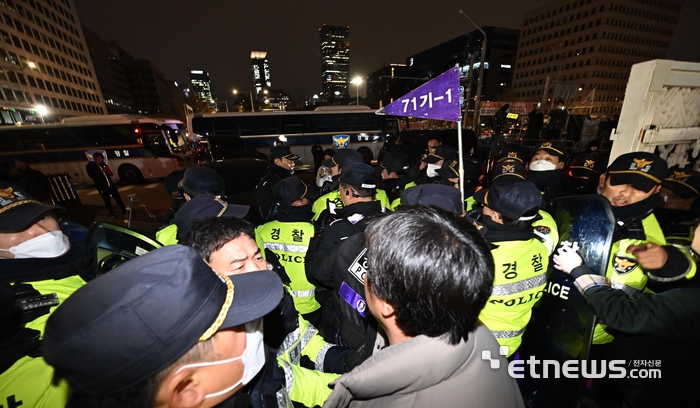 윤석열 대통령이 3일 밤 비상계엄령을 선포한 가운데 폐쇄가 결정된 국회 정문에서 경찰과 국회 관계자들이 대치하고 있다.
 이동근기자 foto@etnews.com