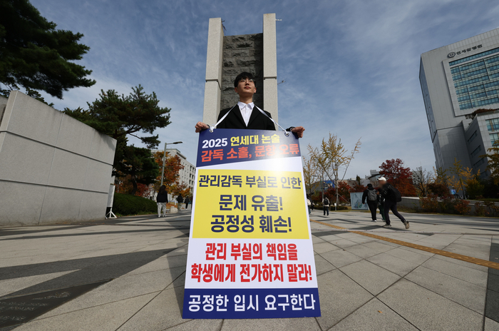 4일 서울 서대문구 연세대학교 정문 앞에서 연세대 재시험 집단소송의 후원자 중 한 명인 정 모 씨가 논술문제 유출 등을 규탄하며 1인 시위를 하고 있다. 연합뉴스