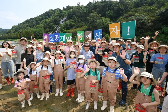 충북 진천군 미르숲 멸종위기종 미호종개 방류행사에서 현대모비스 임직원과 아이들이 기념촬영을 하고 있다.