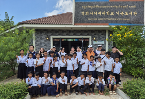 관광레저항공경영학과 윤병국, 임근욱 교수가 뜩틀라 초등학교 도서관을 방문하고 기념사진을 촬영하고 있다. 우측 상단은 경희사이버대학교 기증 도서관 명패다. 사진=경희사이버대학교.