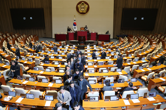 우원식 국회의장이 7일 오후 국회 본회의에서 윤석열 대통령의 탄핵소추안에 대해 의결 정족수 부족으로 '투표 불성립'을 선언하자 의원들이 나가고 있다.