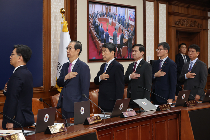 한덕수 국무총리가 10일 서울 종로구 정부서울청사에서 열린 국무회의에서 국무위원들과 국기에 경례하고 있다. 연합뉴스.