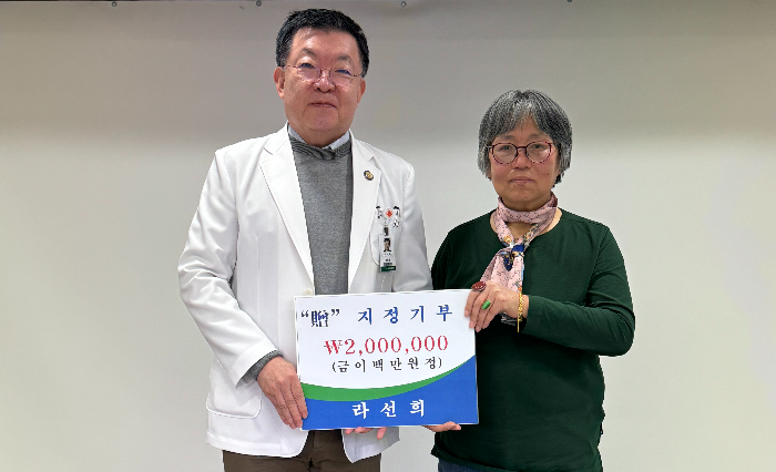 소외된 이웃을 위해 성애병원에 200만원을 기부한 라선희씨(오른쪽)와 김석호 성애병원 이사장. 사진=성애병원