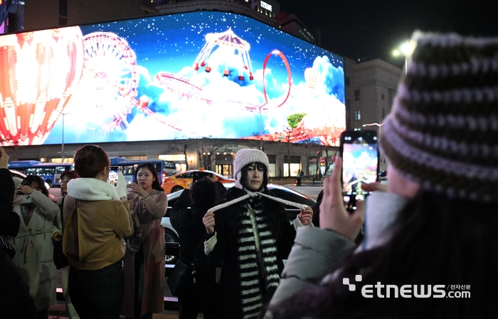 미디어파사드 앞에서 기념촬영하는 시민들