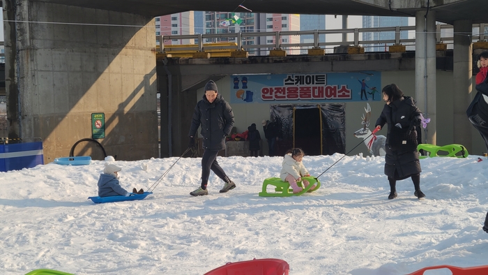 어린이 눈놀이장에서 썰매를 끌고 있는 가족. 사진=성북구 제공