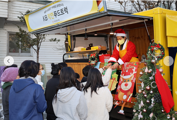 지난 23일 수원시에 위치한 동광원에서 'KB착한푸드트럭' 1호점 대표가 간식을 전달하고 있다