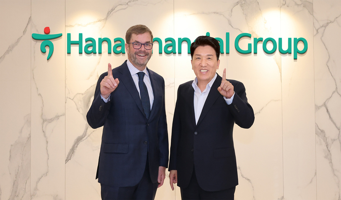 함영주 회장(오른쪽)과 존 코노턴(John Connaughton) 베인캐피탈 글로벌 CEO가 지난 17일 서울시 중구 을지로 소재 하나금융그룹 명동 사옥에서 기념 촬영을 하고 있다.
