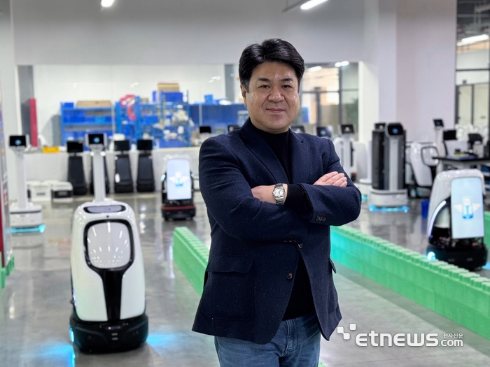 엄인섭 TXR 대표가 자사 로봇 제품을 배경으로 포즈를 취했다.