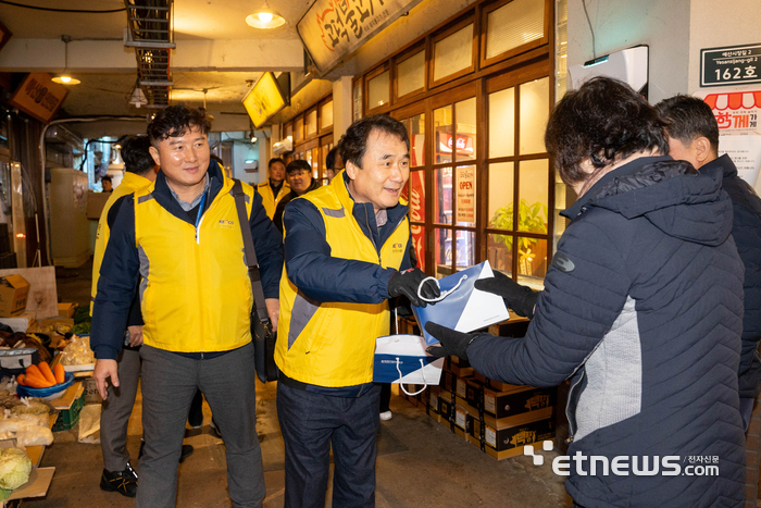 남화영 전기안전공사 사장이 20일 예산시장 방문객에게 전기안전 기념품을 전달하고 있다.