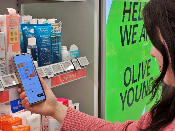 올리브영 매장에서 한 고객이 '전자라벨-NFC 기반 상품 탐색 서비스'를 이용하고 있다.