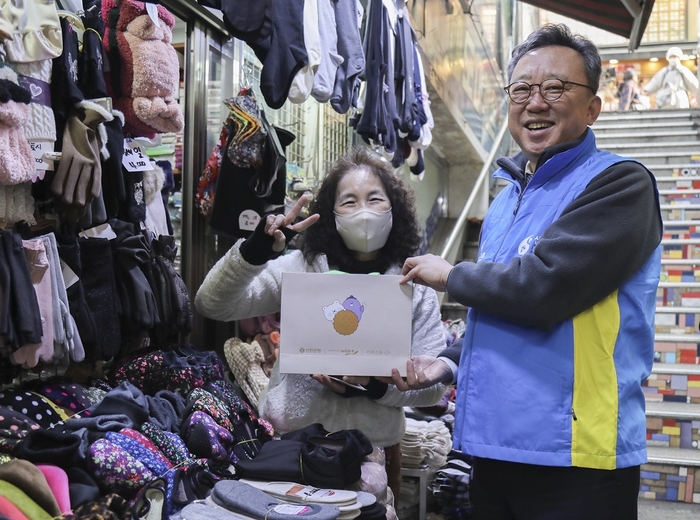 지난 22일 서울시 중구 소재 남대문시장 일대에서 '설맞이 상생캠페인'을 진행하고 정상혁 신한은행장이 시장 소상공인에게 선물을 전달하고 기념촬영하고 있다.