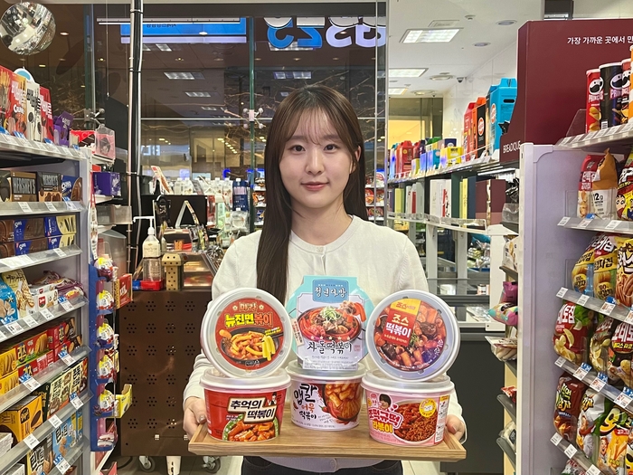 모델이 '빨간 맛'을 테마 냉장 떡볶이 23종 통합 '다다익선' 행사를 소개하고 있다.