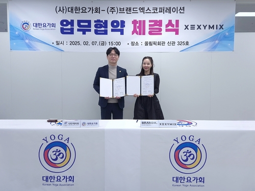이수연 브랜드엑스코퍼레이션 회장(오른쪽)과 강승진 대한요가회 회장이 협약서에 서명한 후 기념 촬영을 진행하고 있다. [자료:브랜드엑스코퍼레이션]